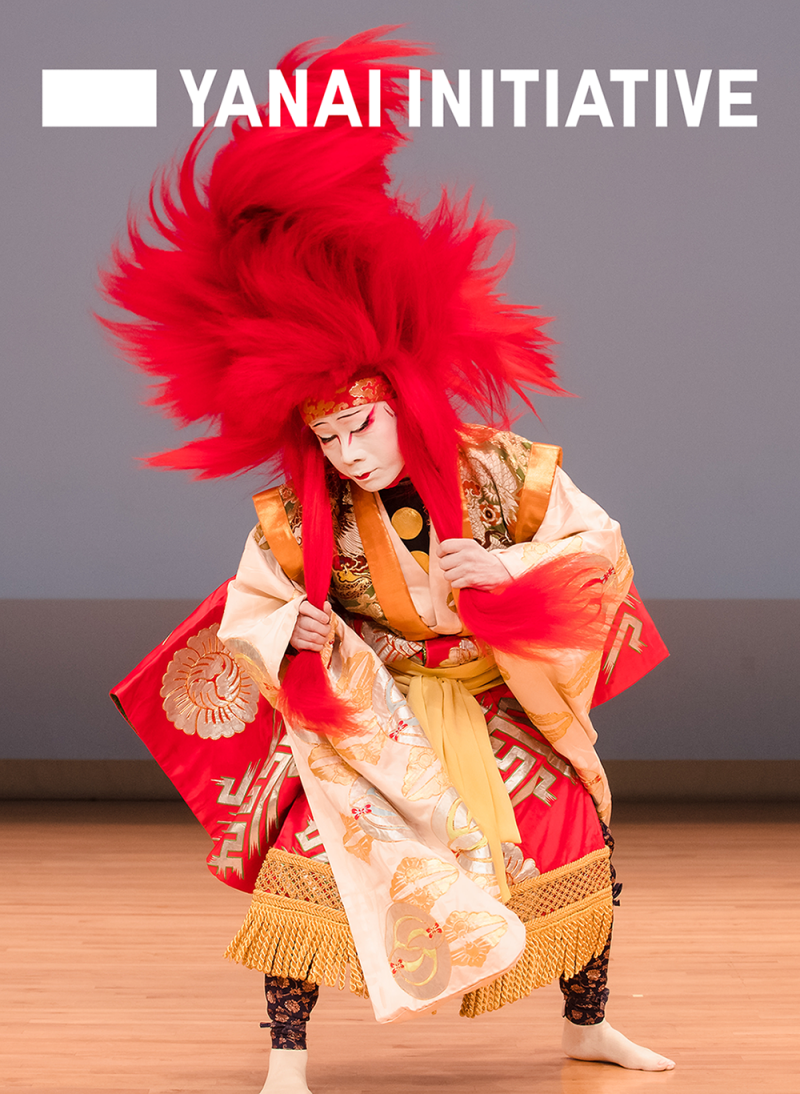 Poster with Yanai Initiative logo at top showing Kabuki actor Nakamura Kyozo in a 2019 performance with bright red feather headpiece.