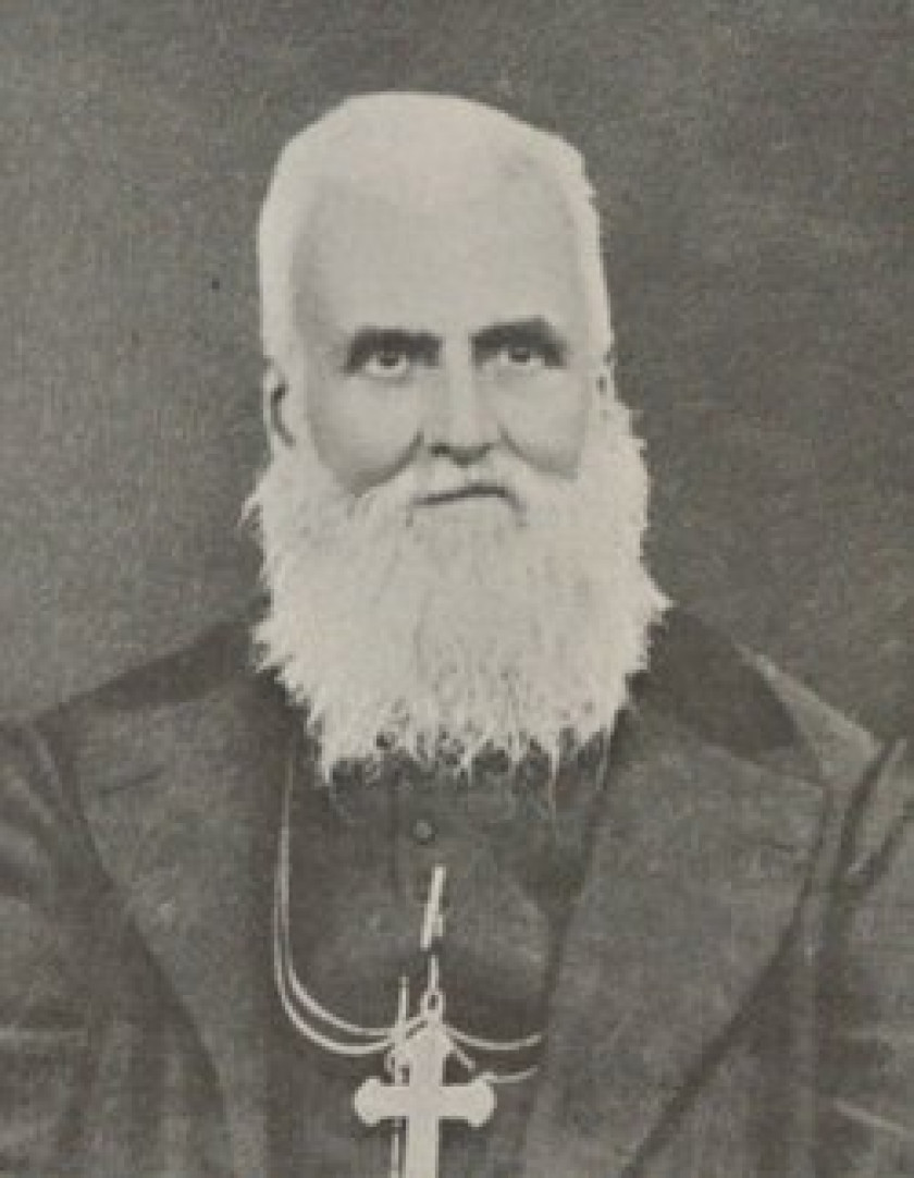 Photograph portrait of Jule-Alphonse Cousin. A senior Caucasian Catholic priest with long white beard in jacket with cross necklace.