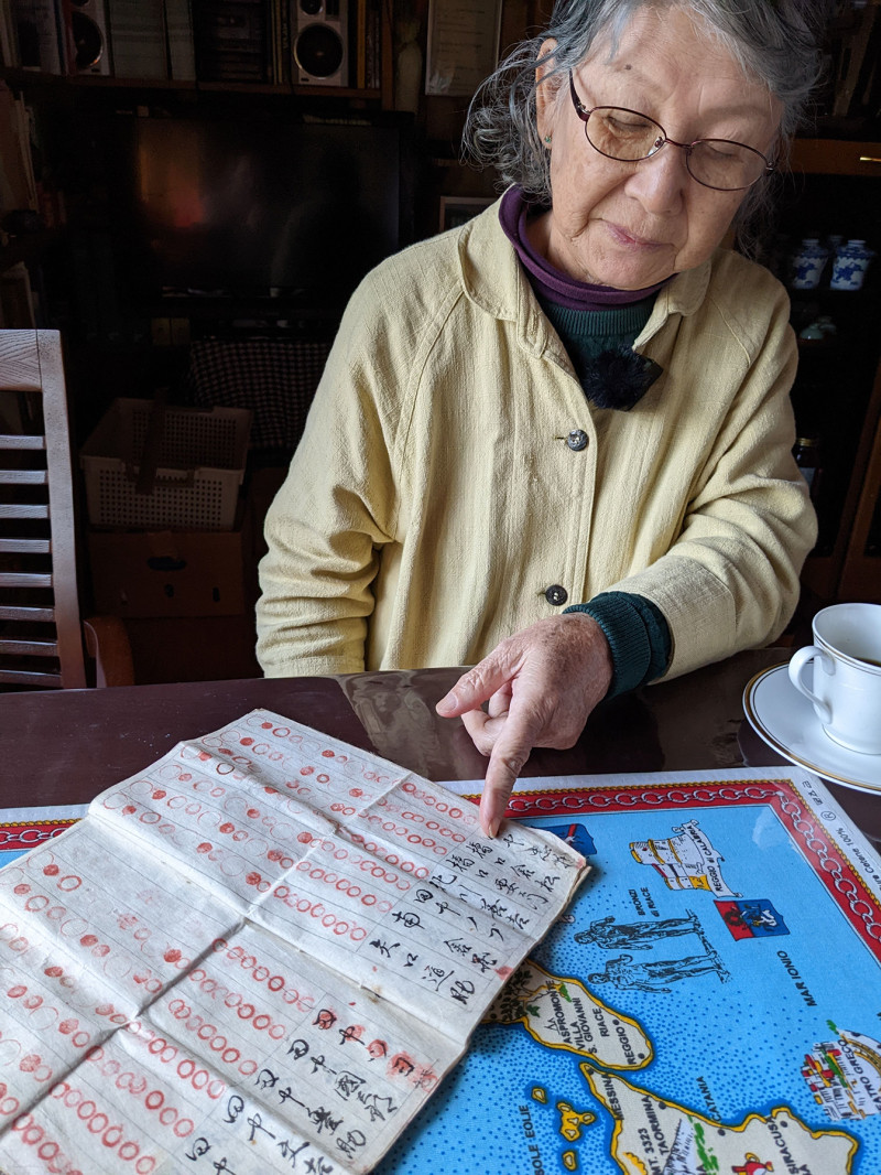 A photograph of Urakami Sachiko pointing at an old, historical piece of paper. She is at the Hidden Christian Museum, Naru Island.