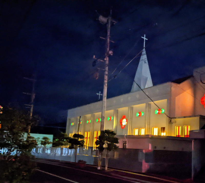 6am Mass at Fukue Catholic Church, Fukue Island. White colored church building with dark background in early morning.