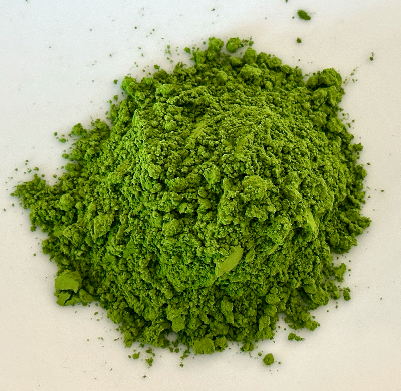 An overhead view of a pile of ground matcha powder, which is bright green.
