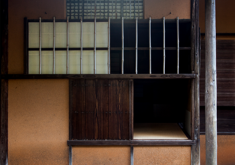 A crawl-through entrance to a tea room with a dark brown wooden door and a small shoji window above.