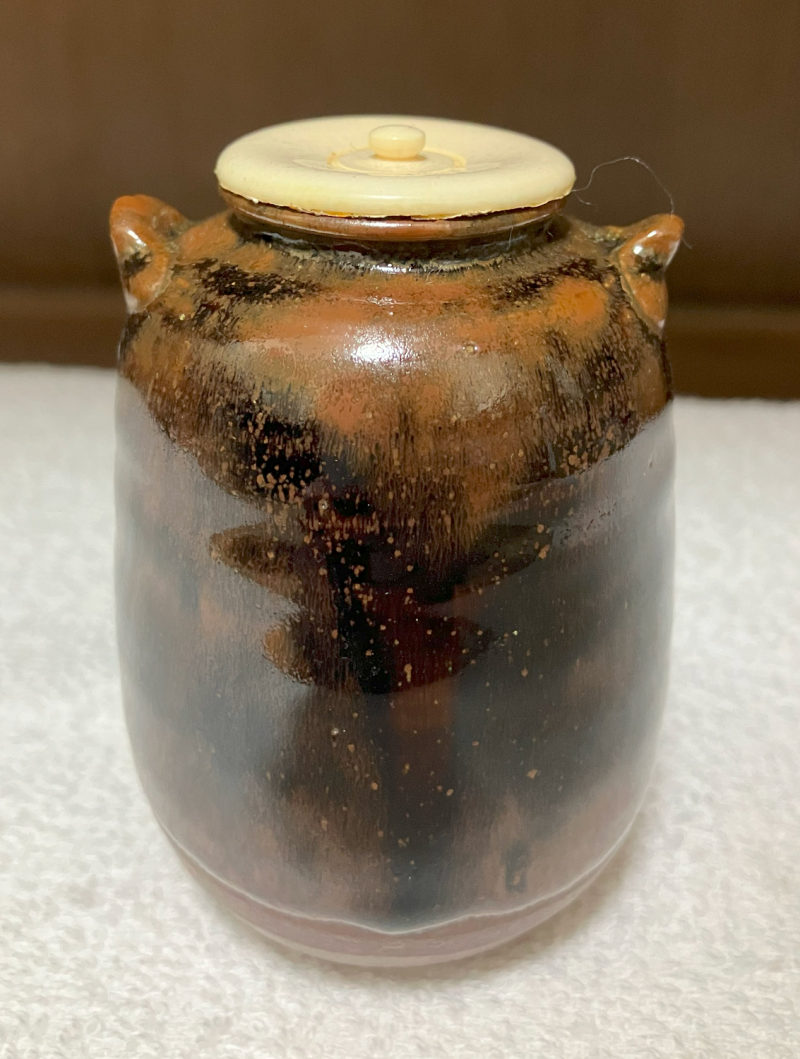 mottled brown and tan ceramic small jar for thick tea with two lugs and imitation ivory off white lid.