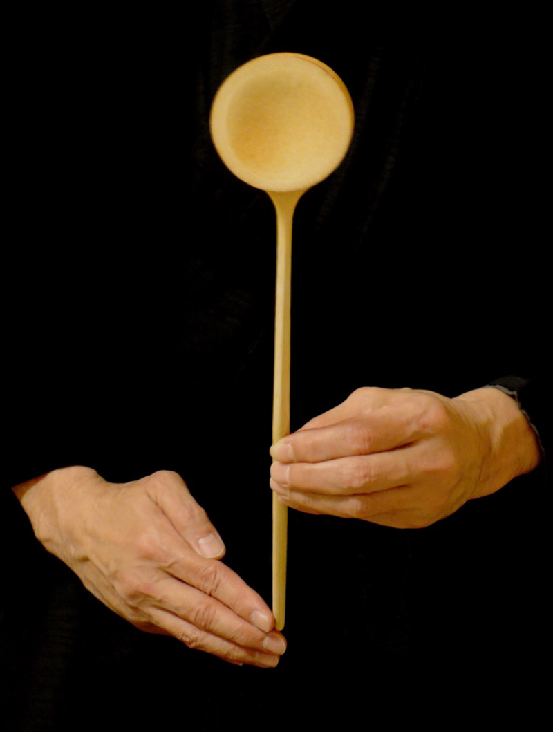 Bamboo ladle for hot and cold water, held vertically in the hands of a host. The cup of the ladle is made from a piece of bambo with its node as the bottom with a long piece of bamboo with one central node held in a slot in the side of the cup by pressure.