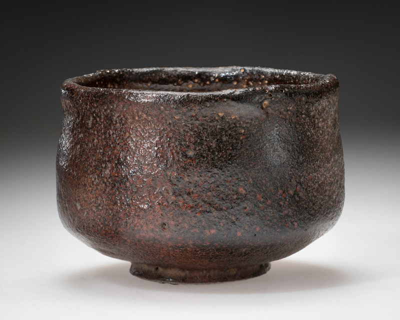 A highly textured Raku ware teabowl in shades of black and red.